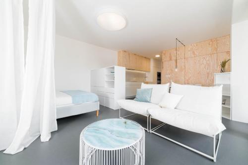 ein Wohnzimmer mit einem weißen Sofa und einem Tisch in der Unterkunft White Innk city center apartment in Trnava