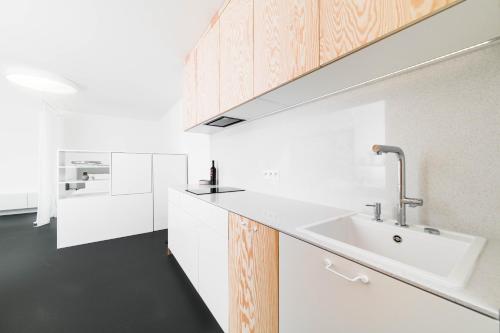 a kitchen with a white counter and a sink at White Innk city center apartment in Trnava