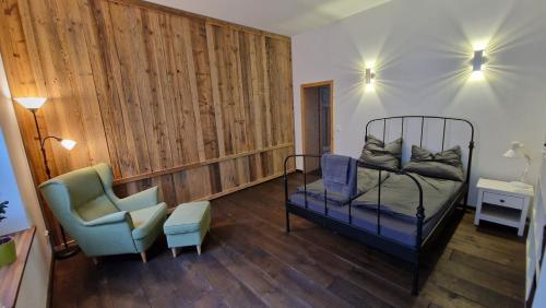 ein Schlafzimmer mit einem Bett und einem Stuhl in der Unterkunft Liebevoll sanierte Altbauwohnung in Waldsieversdorf