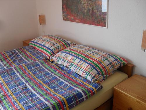 a bed with a colorful comforter and two pillows at Santa Maria Ferienwohnung in Ronco sopra Ascona