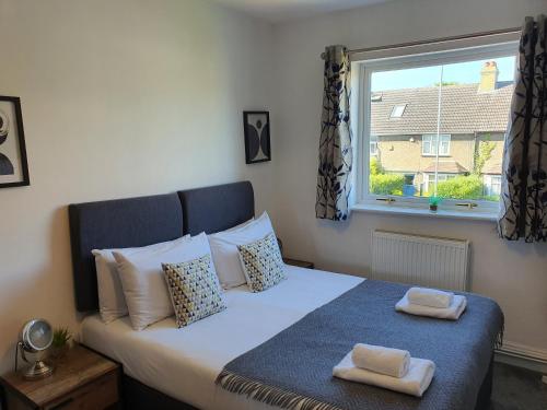 a bedroom with a bed with two towels on it at North Cambridge Guesthouse by Payman Club in Cambridge