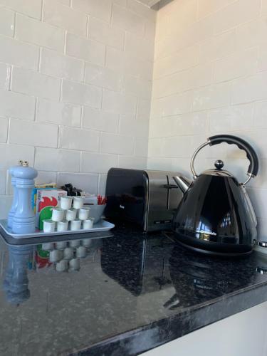 a tea kettle sitting on a counter next to a toaster at Old Nursery in Coity