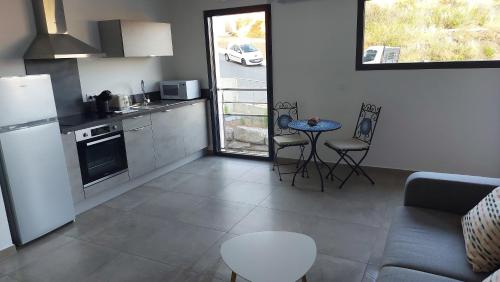 une cuisine et un salon avec un canapé et une table dans l'établissement Appartement neuf à 5 min de la plage et de l'aéroport, à Ajaccio