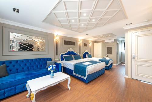 a hotel room with a bed and a blue couch at Begonville Mansion Oldcity in Istanbul