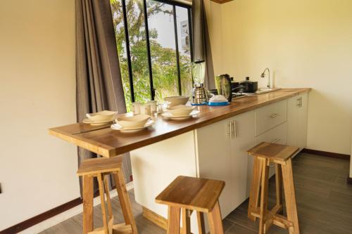 a kitchen with a counter with stools and a window at Bunker593 Inn in Tena