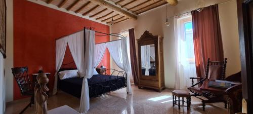 Petrignano的住宿－Il Nido del Cuculo，一间卧室配有天蓬床和镜子