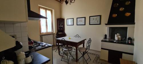 kuchnia ze stołem, krzesłami i kuchenką w obiekcie Il Nido del Cuculo w mieście Petrignano