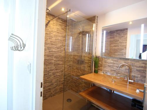 a bathroom with a sink and a glass shower at Appartement Chamrousse, 2 pièces, 4 personnes - FR-1-340-259 in Chamrousse