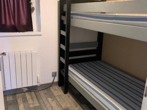 a bunk bed in a room next to a window at Appartement Chamrousse, 2 pièces, 4 personnes - FR-1-340-259 in Chamrousse