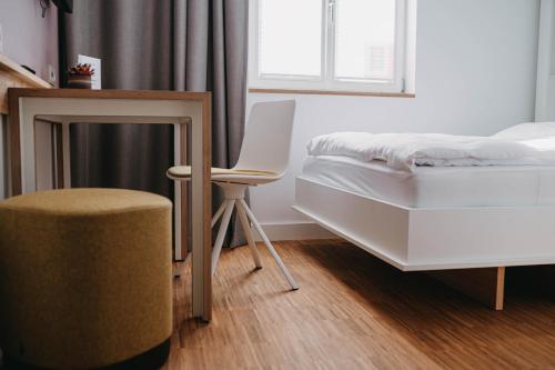 a bedroom with a bed and a chair and a window at Maximilian Studios in Speyer