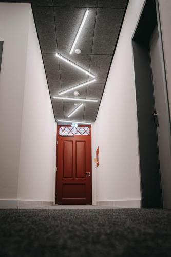 a hallway with a red door in a building at Maximilian Studios in Speyer