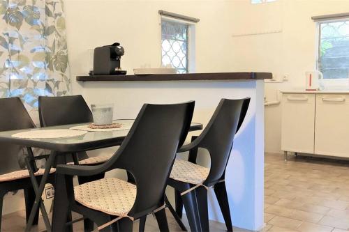 a dining room with a table and chairs in a kitchen at Maison dans le quartier historique de St Laurent Résidence Colibri in Saint-Laurent du Maroni