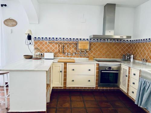 a kitchen with white counters and a stove top oven at Villa ALJARAL, Espectacular,piscina,chimenea, climatización, wifi in Córdoba