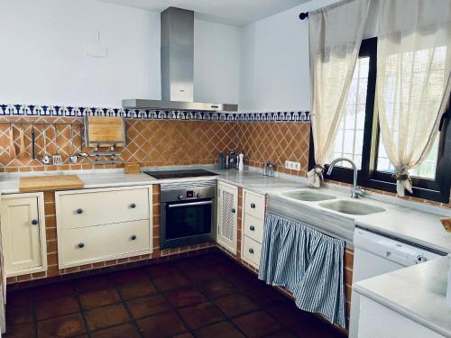 a kitchen with a sink and a stove at Villa ALJARAL, Espectacular,piscina,chimenea, climatización, wifi in Córdoba