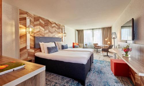 a hotel room with a bed and a desk at Carlton Beach in Scheveningen