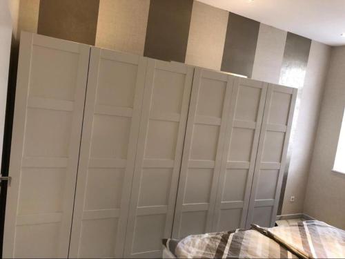 un armadio con porte bianche in una camera da letto di Ferienwohnung Zollverein a Essen