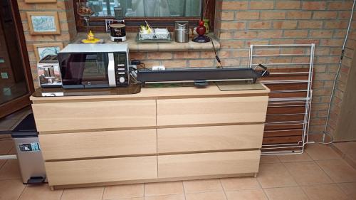 un microondas sentado en la parte superior de un mostrador en Chambre plein confort, en Vimy