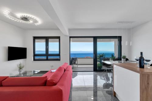a living room with a red couch and a kitchen at Luxury Penthouse Berlin in Makarska