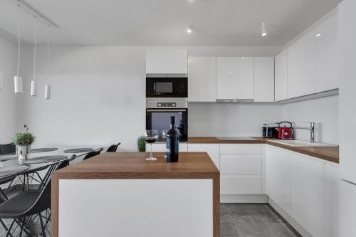 a kitchen with white cabinets and a table with chairs at Luxury Penthouse Berlin in Makarska