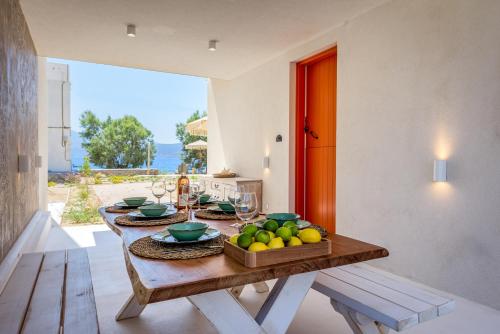 a dining room with a table with a bowl of fruit at KLIMA BAY Beachfront Boutique Houses in Klima