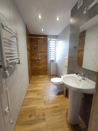 a bathroom with a white sink and a toilet at Apartamenty NOVA - BLISKO ENERGYLANDII in Zator