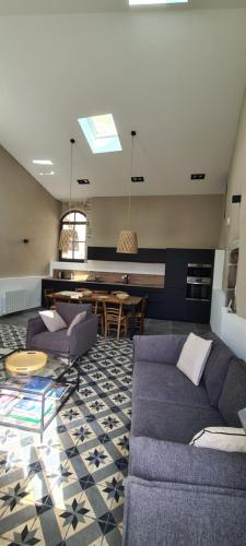 a living room with a couch and a table at Magnifique maison en coeur de Balazuc, proche plages ardèche in Balazuc