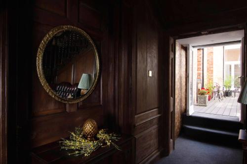 a mirror on a wooden wall in a room at Stone Court House in Maidstone