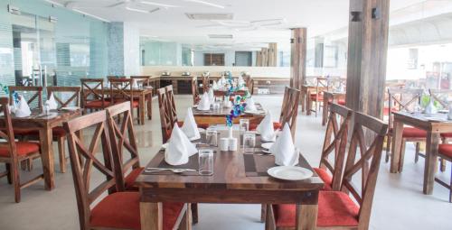 une salle à manger avec des tables et des chaises en bois dans l'établissement DIDI Hotel Alambagh, à Lucknow
