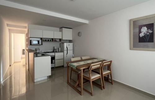 a kitchen with a table and chairs and a refrigerator at Departamento Alva in Bahía Blanca