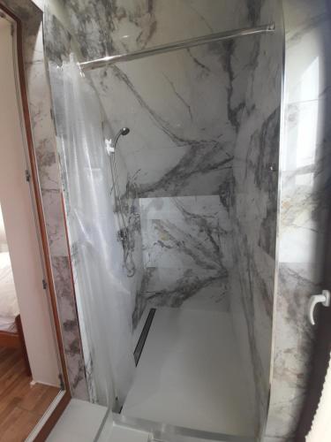 a bathroom with a shower with a marble wall at Noclegi u Banysia w sercu Gór Świętokrzyskich in Krajno Pierwsze