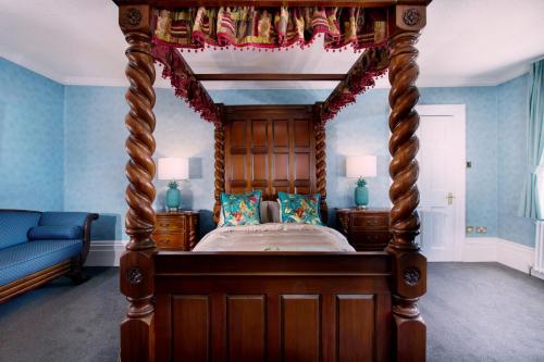 a canopy bed in a bedroom with blue walls at Stone Court House in Maidstone