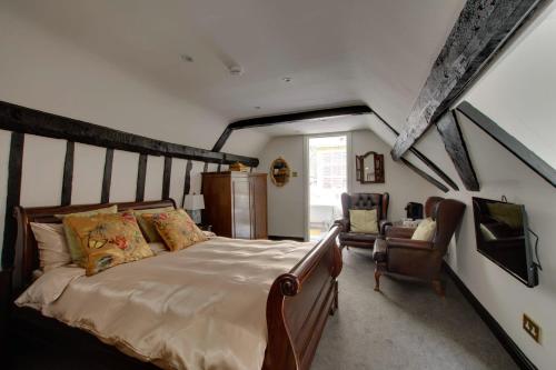 a bedroom with a large bed and a chair at Stone Court House in Maidstone