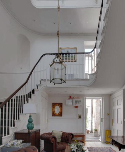 a living room with a staircase and a couch at Stone Court House in Maidstone
