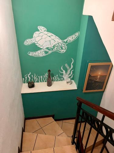a staircase with a green wall with a turtle painted on it at A’s Beach Apartment in Flic-en-Flac