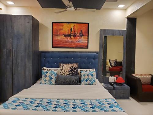 a bedroom with a bed with a blue headboard at Hotel Mari Aai Residency in Navi Mumbai