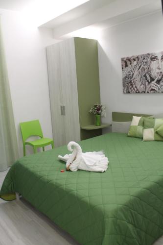 Zimmer mit grünem Bett mit ausgestopftem Tier in der Unterkunft Vista Normanna in Pietra Montecorvino