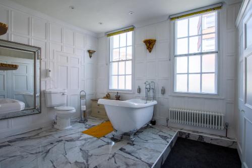 a white bathroom with a tub and a toilet at Stone Court House in Maidstone