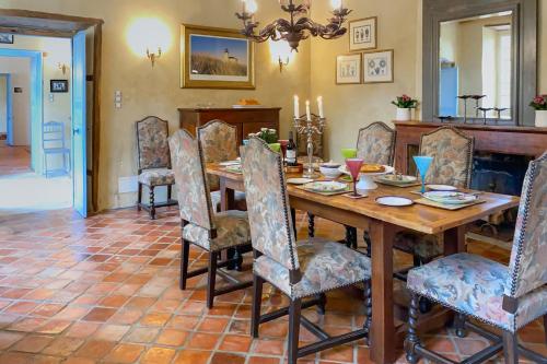 a dining room with a wooden table and chairs at Maison Manechal in Monfaucon