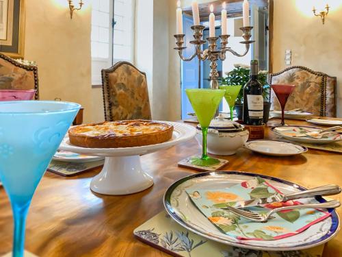 a dining room table with a pie and wine glasses at Maison Manechal in Monfaucon