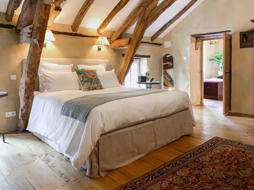 a bedroom with a large bed in a room with wooden ceilings at Maison Manechal in Monfaucon