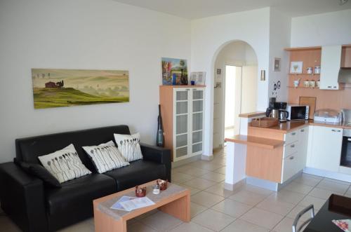 a living room with a black couch and a kitchen at Ferienwohnung-Casa-Uta-Gardasee-Limone-Tremosine in Tremosine Sul Garda