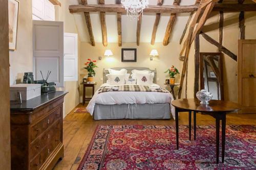 a bedroom with a bed and a table and a rug at Maison Manechal in Monfaucon