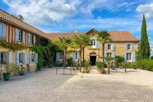 a large house with palm trees in a courtyard at Maison Manechal in Monfaucon