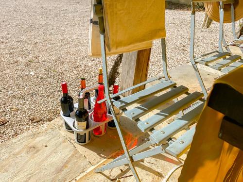 a chair with a bunch of bottles of wine at Maison Manechal in Monfaucon
