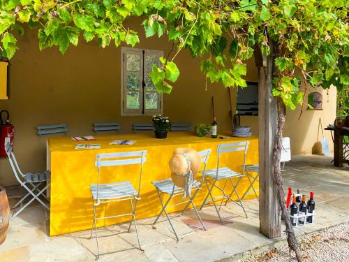 a yellow table and chairs with a person sitting on it at Maison Manechal in Monfaucon