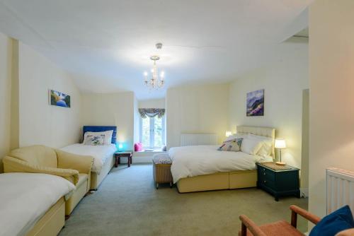 a bedroom with two beds and a couch in it at Pen-Y-Bont Hotel in Tal-y-llyn