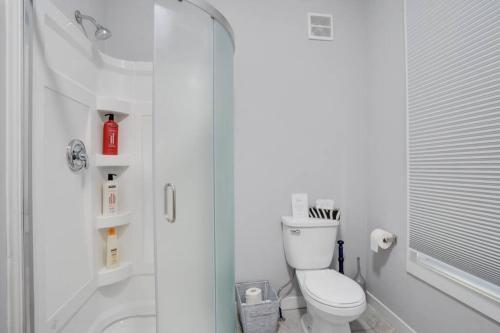 ein weißes Bad mit einer Dusche und einem WC in der Unterkunft Modern & Private 1-Bedroom Apartment in Windsor