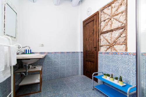 敘拉古的住宿－A 50 passi dal Tempio di Apollo，浴室设有水槽和蓝色瓷砖淋浴。