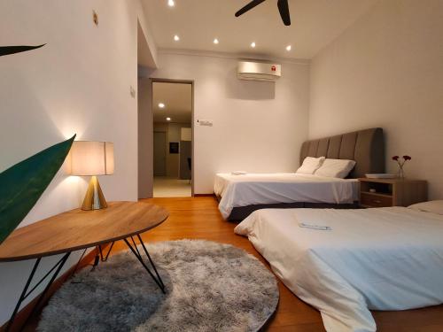 una camera da letto con due letti e un tavolo con una lampada di KLGateway Premium Residence Mid Valley a Kuala Lumpur