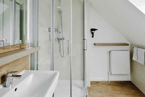 a bathroom with a sink and a shower at Duus Hotel garni in Wyk auf Föhr